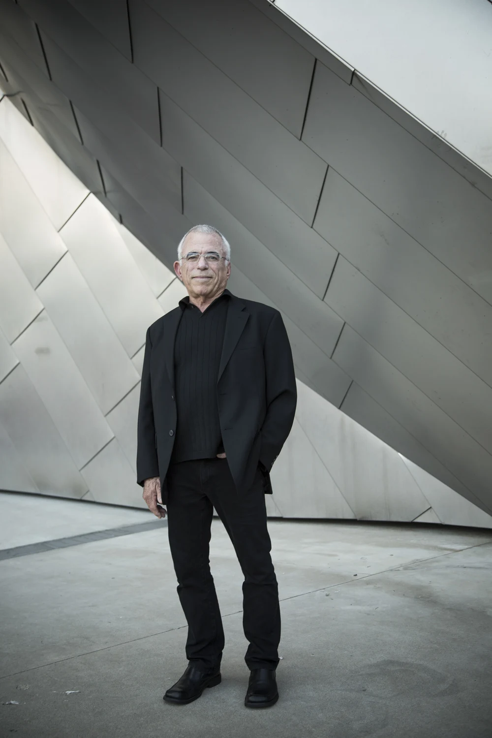 Rob Janoff photographed against sculptural architecture